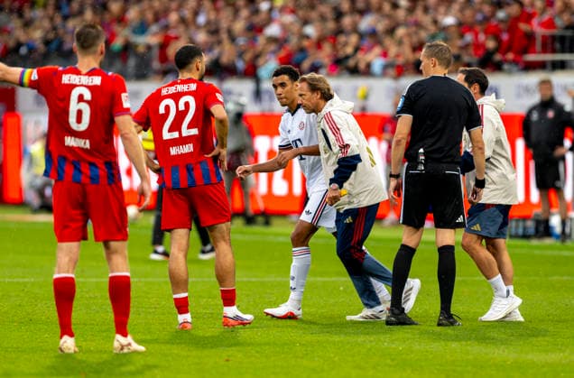 August 18, 2026, 2026–2027 Bundesliga season, friendly match, 1. FC Heidenheim vs. FC Bayern Munich, at the Voith Arena in Heidenheim; after collapsing again during the game, Jamal Musiala (center), of Bayern Munich, is treated by team doctor Prof. Dr. Peter Ueblacker and led off the field