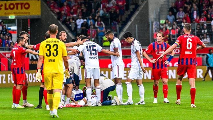 August 18, 2026, GER, Soccer, Men s, FSP, 1 FC Heidenheim vs. FC Bayern Munich: Jamal Musiala (Bayern Munich, No. 10) collapses on the field without any outside influence; players from both teams then form a screen to block the view. Heidenheim Voith Arena, Baden-Württemberg, Germany Copyright: xNordphotox xHafnerx