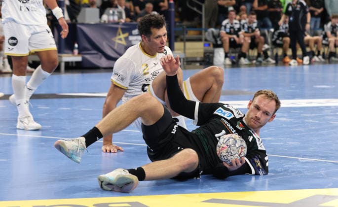 Thiagus Goncalves dos Santos, Mathias Gidsel on the floor after a tackle; game scene; action; sports; handball; Champions League; Men s Champions League; Matchday 2; 2026–2027 season; September 16, 2026; Füchse Berlin vs. One Veszprém HC at the Max Schmeling Halle