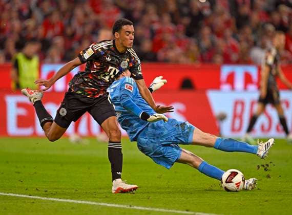 September 18, 2026, 2026–2027 Bundesliga, Matchday 4, FC Bayern Munich vs. 1. FC Union Berlin, at the Allianz Arena in Munich, Jamal Musiala (Bayern Munich) vs. goalkeeper Frederik Rönnow (Union Berlin)