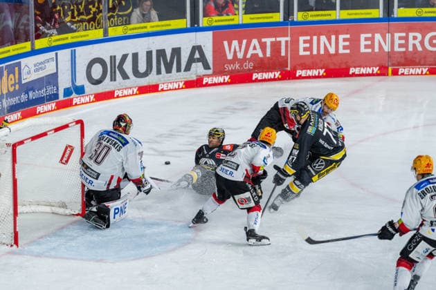 Kristers Gudlevskis, Fischtown Pinguins Bremerhaven, 30, C J Suess is knocked to the ice by No. 91 during a battle for the puck on the offensive end; Akito Hirose, Fischtown Pinguins Bremerhaven, 02, Mick Koehler, Krefeld Pinguine, 77, Krefeld Pinguine vs. Pinguins Bremerhaven, ice hockey, PENNY DEL, Matchday 1, 2026–2027 season, September 18, 2026, Krefeld Pinguine vs. Pinguins Bremerhaven, ice hockey, PENNY DEL, Matchday 1, 2026–2027 season, September 18, 2026, Krefeld Copyright: xEibner-Pressefoto LukasxBaldygax EP_LBA