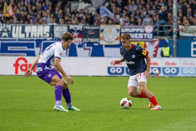 September 19, 2026 Soccer, 2. Bundesliga Men, 2026–2027 Season, Matchday 6: Holstein Kiel vs. VFL Osnabrück. Kiel in white and blue; Osnabrück in robin red. Fabinski (left), Gyan de Regt. Holstein Stadium, Westring 501, Schleswig-Holstein, Germany