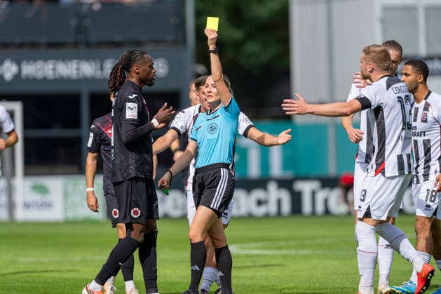 Yannick Tonye of Viktoria Köln, No. 07, receives a yellow card after a handball by Fabienne Michel, the referee; Lars Lokotsch of FC Ingolstadt 04, No. 13, protests, Keanan Bennetts of FC Ingolstadt 04, No. 18; FC Viktoria Köln vs. FC Ingolstadt 04, soccer, 3. Liga, Matchday 7, 2026–27 season, September 19, 2026, DFL regulations prohibit any use of photographs as image sequences and or quasi-video. FC Viktoria Köln vs. FC Ingolstadt 04, soccer, 3. Liga, Matchday 7, 2026–27 season, September 19, 2026, Cologne Copyright: xEibner-Pressefoto LukasxBaldygax EP_LBA