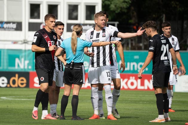 German Soccer, 3rd Division, 2026–27, Matchday 7, September 19, 2026, FC Viktoria Köln vs. FC Ingolstadt 04, Sportpark Höhenberg, Cologne. Referee Fabienne Michel signals an offside against Lars Lokotsch of FC Ingolstadt 04, No. 13, Lucas Wolf of FC Viktoria Cologne, No. 21, and David Otto of FC Viktoria Cologne, No. 10, for being offside. Cologne, Germany Copyright: xMijoxLubecx