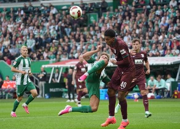 Photo: Niclas FÜLLKRUG, Werder, on the left, scoring with a bicycle kick against Noahkai Banks, Augsburg. Soccer, Bundesliga 1, Matchday 30, Saturday, April 18, 2026: Werder Bremen vs. Hamburger SV