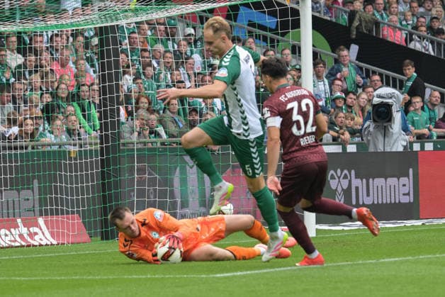 Goalkeeper Karl Hein of SV Werder Bremen 1 makes a save against Fabian Rieder of FC Augsburg 32; SV Werder Bremen vs. FC Augsburg, soccer, Bundesliga, DFL, September 19, 2026. DFB regulations prohibit any use of photographs as image sequences and or quasi-video. Bremen, Germany Copyright: xkolbert-press BurghardxSchreyerx