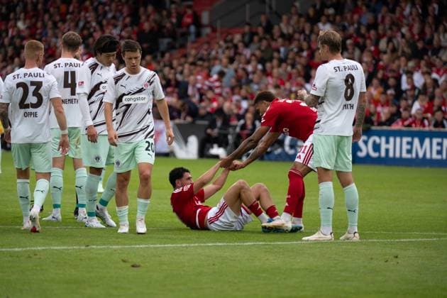 September 20, 2026: Energie Cottbus vs. FC St. Pauli, Matchday 6 of the 2. Bundesliga at the LEAG Energie Stadium; Justin Butler (Energie Cottbus), 31, assists Tolcay Cigerci (Energie Cottbus), 10 getting back on their feet IMPORTANT NOTICE: In accordance with DFL and DFB regulations, it is prohibited to use or allow the use of photographs taken in the stadium and or during the game in the form of sequential images and or video-like photo series. Copyright: xJamesxZabelx