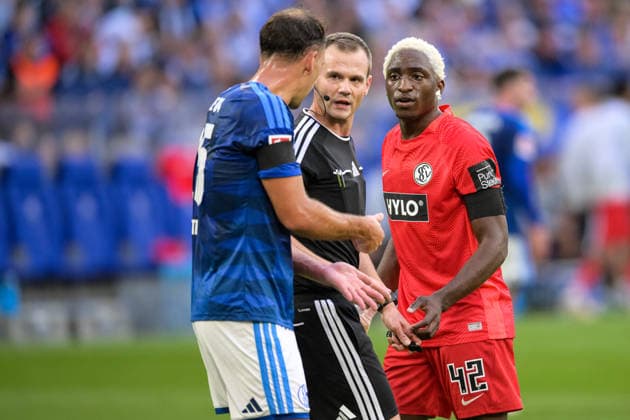 Soccer, Bundesliga 1, September 20, 2026, FC Schalke 04 vs. SC 07 Elversberg Pictured, from left: Nikola KATIC (Schalke), 25; referee Robin BRAUN; and David MOKWA (Elversberg), 42; Gelsenkirchen, Veltins Arena, North Rhine-Westphalia, Germany Copyright: Passion2Press MarkusxFischerx