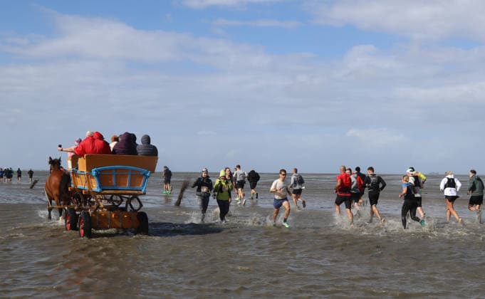Participants in the 2nd Red Bull Watt Run from the beach in Duhnen to Neuwerk and back. Because a strong westerly wind had pushed a lot of water into the southwestern part of the German Bight in the days leading up to the event, the route had to be adjusted.