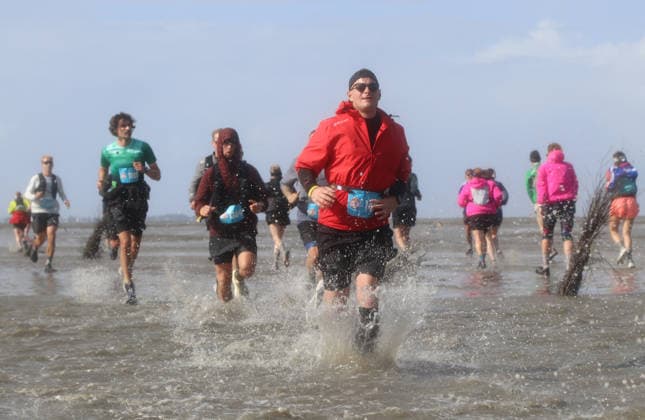 Participants in the 2nd Red Bull Watt Run from the beach in Duhnen to Neuwerk and back. Because a strong westerly wind had pushed a lot of water into the southwestern part of the German Bight in the days leading up to the event, the route had to be adjusted.