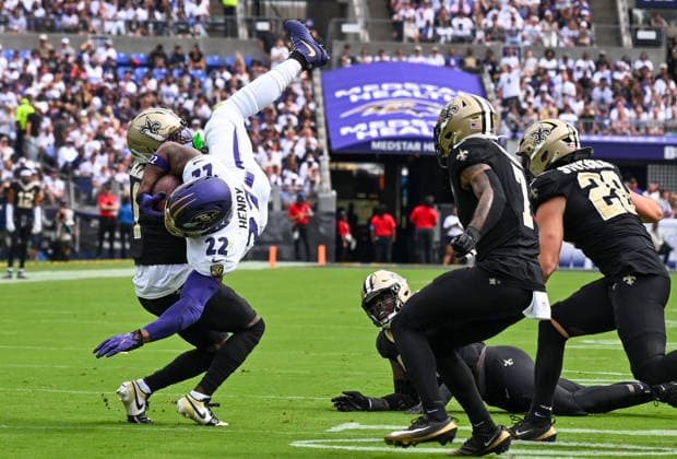 Baltimore Ravens running back Derrick Henry (22) is upended by New Orleans Saints cornerback Kool-Aid McKinstry (1) on a first down run during the first quarter of the Ravens home opener game at M&T Bank Stadium in Baltimore, Maryland, on Sunday, September 20, 2026.  BAL20260920116 DAVIDxTULIS