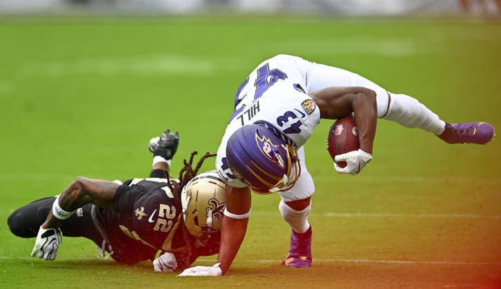 Baltimore Ravens running back Justice Hill (43) is upended by New Orleans Saints cornerback Martin Emerson (22) during the second quarter of the Ravens home opener game at M&T Bank Stadium in Baltimore, Maryland, on Sunday, September 20, 2026.  BAL20260920127 DAVIDxTULIS