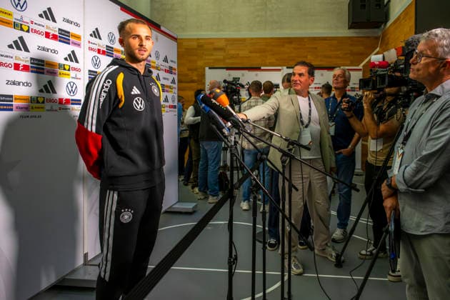 September 22, 2026, Soccer: DFB German National Team, training camp in Herzogenaurach, at the ADIDAS headquarters, ahead of the UEFA Nations League matches; media mixed zone with three national team players speaking with the press in attendance. Here, Max Rosenfelder of Germany stands before the journalists and their microphones.