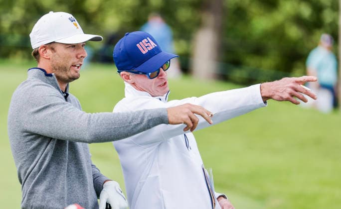 Sam Burns of the US (L) consults with caddie Travis Perkins (R) as he prepares to hit a tee shot on the twelfth hole during practice for the Presidents Cup golf tournament at Medinah Country Club in Medinah, Illinois on Tuesday, September 22, 2026. Competition between the USA and the International team begins on Thursday, September 24 with Four-Ball play.  MED20260922914 TANNENxMAURY