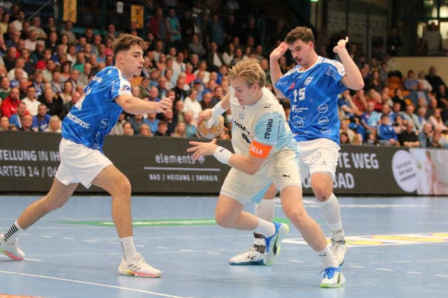 September 23, 2026 Men s Handball 2026–2027 DHB Cup, Round 2: Dessau Roßlauer HV 06 vs. VfL Gummersbach, Anhalt Arena, Dessau; Ellidi Vidarsson (Gummersbach), 4, in white with the ball; Marcel Nowak (Dessau), 15, blue, and Alen Hadzimuhamedovic Dessau, 11, blue, arrive too late Dessau-Roßlau, Saxony-Anhalt, Germany