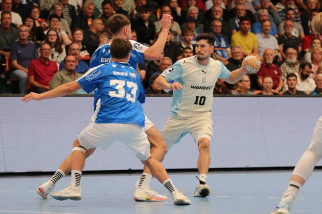 September 23, 2026 Men s Handball 2026–2027 DHB Cup, Round 2: Dessau Roßlauer HV 06 vs. VfL Gummersbach at Anhalt Arena, Dessau; Alex Dujsh-eb-aev (Gummersbach), 10, in white with the ball, Alen Hadzimuhamedovic (Dessau), 11, in blue, and Simon Sirot (Dessau), 33, in blue, await their opponent Dessau Roßlau, Saxony-Anhalt, Germany