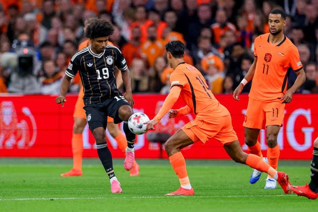 September 24, 2026, Soccer, International Match, Netherlands vs. Germany, Kickoff of the 2026–2027 UEFA Nations League, Matchday 1, Johan Cruijff ArenA, Amsterdam, 2026–27 season: Karim Adeyemi (GER, 19) in a tackle against Tijjani Reijnders (NED, 14). DFB regulations prohibit any use of photographs as image sequences and or quasi-video. Netherlands