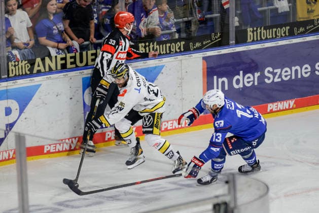 September 25, 2026, xhettx, Penny DEL Ice Hockey, Adler Mannheim vs. Krefeld Pinguine; from left: C. J. Suess (Krefeld Pinguine), 27 clears the puck in front of Brooks Macek (Adler Mannheim), 13
