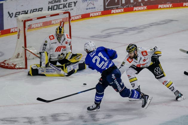 September 25, 2026, xhettx, Penny DEL Ice Hockey, Adler Mannheim vs. Krefeld Pinguine; Kris Bennett (Adler Mannheim, 21) shoots on the goal of Juha Jatkola (Krefeld Pinguine, 32)