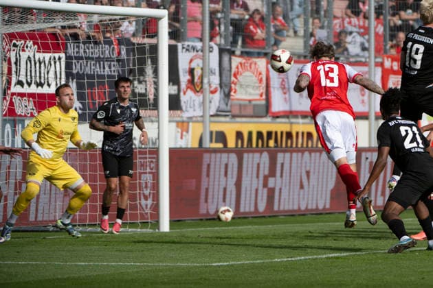 Regionalliga Northeast, Season 26-27: Hallescher FC vs. BFC Preussen Berlin 1894 e.V., Halle, Germany, September 26, 2026. Pictured from left: Goalie Florian Palmowski (Berlin) and Niclas Stierlin (Halle) scoring the goal that made it 3–2 at the Halle Saale Leuna Chemie Stadium in Saxony-Anhalt, Germany.