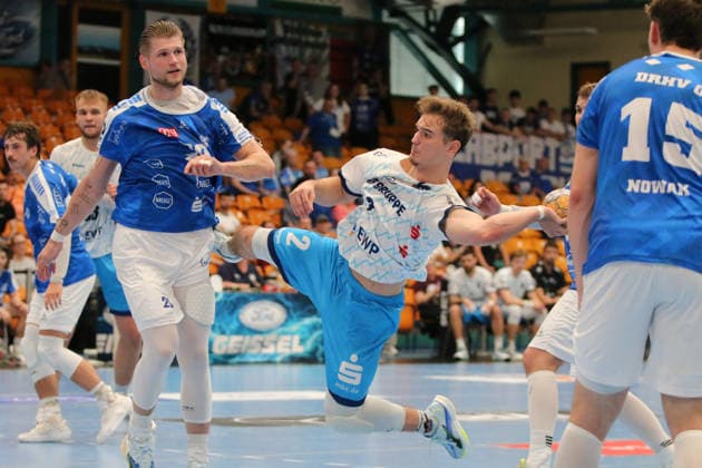 September 26, 2026 Men s Handball 2026–2027, 2nd Division, Matchday 5: Dessau Roßlauer HV 06 1 VfL Potsdam, Anhalt Arena, Dessau. Florian Budde (Potsdam), 2, in white, takes a shot on goal; Leon Ciudad of Dessau, 20, in blue, is unable to block it. Dessau-Roßlau, Saxony-Anhalt, Germany