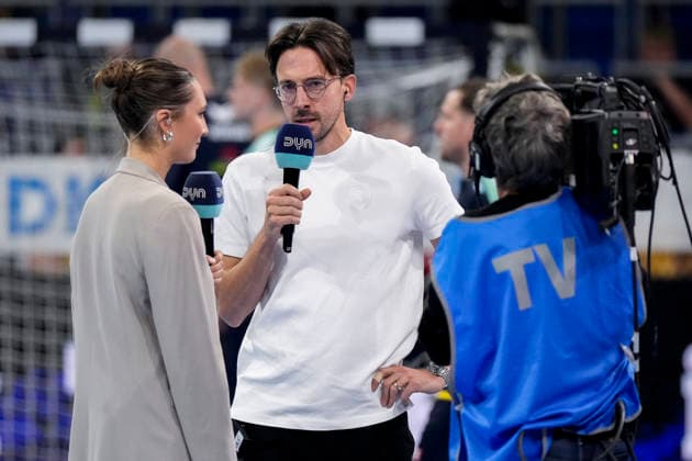 Patrick Groetzki (RNL) holding a microphone during an interview with DYN TV, September 26, 2026, Mannheim, Germany; handball, Bundesliga, Rhein-Neckar Löwen vs. MT Melsungen xozx