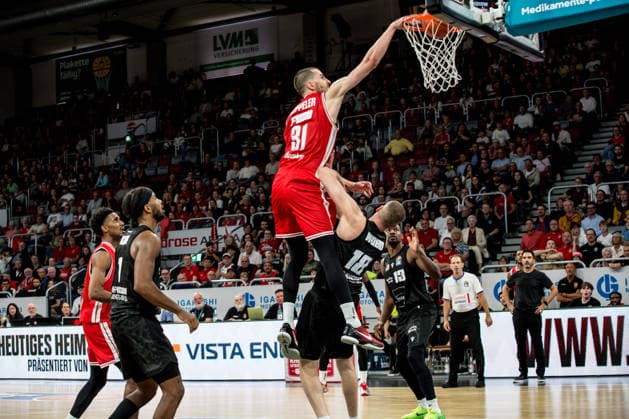 Bamberg, Germany, September 26, 2026, BBL 2026–2027 Season, Game 3: BMA365 Bamberg Baskets vs. MHP Riesen Ludwigsburg. Pictured: Daniel Keppeler of Bamberg soars over the defense of Jonas Wolfarth and Bottermann of Ludwigsburg for a dunk at the Brose Arena in Bavaria. Copyright: xFotostandx xSchmittx