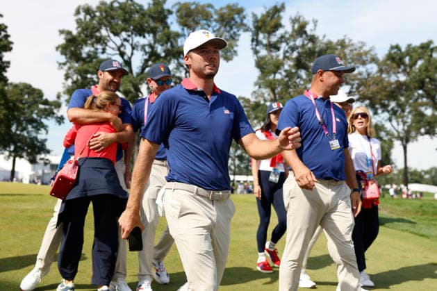 MEDINAH, IL - SEPTEMBER 26: Cameron Young of the United States walks off the No. 17 as Scottie Scheffler of the United States is hugged by his wife Meredith after securing a win in their match during the Saturday four ball session of the Presidents Cup, September 26, 2026, at Medinah Country Club in Medinah, Illinois. (Photo by Matthew Maxey Icon Sportswire) GOLF: SEP 26 Presidents Cup EDITORIAL USE ONLY Icon260926076
