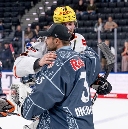 A hug during the post-game handshake between Mathias Niederberger, goalie for EHC Red Bull Munich, 35, and Konrad Abeltshauser of Löwen Frankfurt, 16 (GER), EHC Red Bull Munich vs. Löwen Frankfurt ice hockey, DEL, 2026–2027 season, Matchday 4, September 27, 2026. Photo by HMB Media, Heike Feiner Copyright: HMBxMedia HeikexFeiner