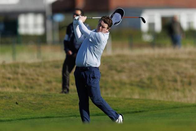 1st October 2026; Carnoustie Golf Links, Carnoustie, Angus, Scotland; DP World Tour Golf, Alfred Dunhill Links Championship, Day 1; Robert Macintyre of Scotland loses his hat in the wind as he plays a shot from the fairway on the seventeenth hole DavidxYoung
