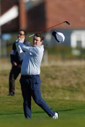 1st October 2026; Carnoustie Golf Links, Carnoustie, Angus, Scotland; DP World Tour Golf, Alfred Dunhill Links Championship, Day 1; Robert Macintyre of Scotland loses his hat in the wind as he plays a shot from the fairway on the seventeenth hole DavidxYoung