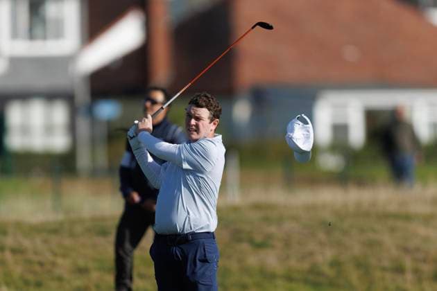 1st October 2026; Carnoustie Golf Links, Carnoustie, Angus, Scotland; DP World Tour Golf, Alfred Dunhill Links Championship, Day 1; Robert Macintyre of Scotland loses his hat in the wind as he plays a shot from the fairway on the seventeenth hole DavidxYoung