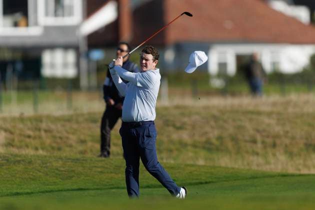 1st October 2026; Carnoustie Golf Links, Carnoustie, Angus, Scotland; DP World Tour Golf, Alfred Dunhill Links Championship, Day 1; Robert Macintyre of Scotland loses his hat in the wind as he plays a shot from the fairway on the seventeenth hole DavidxYoung