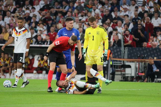 October 1, 2026 Men s Soccer 2026–2027 UEFA Nations League Matchday 3 Germany vs. Serbia Allianz Arena, Munich Waldemar Anton (Germany), No. 3, in white, lies injured on the ground; Espen Eskas (referee) and Jonas Urbig (Germany), 1, yellow, check on him Munich Bayern Germany