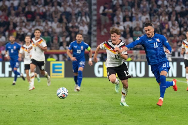 Philipp Treu (13, Germany) and Filip Kostic (11, Serbia) in action during the UEFA Nations League match between Germany and Serbia on October 1, 2026, in Munich at the Allianz Arena, Bavaria, Germany
