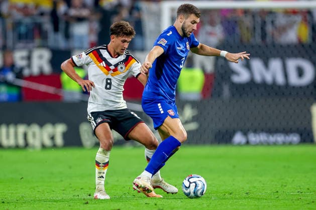 October 1, 2026, Soccer, International Match, Germany vs. Serbia, UEFA Nations League 2026–2027, Matchday 3, Allianz Arena, Munich, 2026–27 season: Tom Bischof (GER 8) in a tackle against Strahinja Pavlovic (SER 3). DFB regulations prohibit any use of photographs as image sequences and or quasi-video. Bayern Munich, Germany