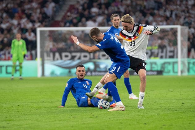 Filip Kostic (No. 11, Serbia), Strahinja Pavlovic (No. 3, Serbia), and Nick Woltemade (No. 11, Germany) in action during the UEFA Nations League match between Germany and Serbia on October 1, 2026, at the Allianz Arena in Munich, Bavaria, Germany