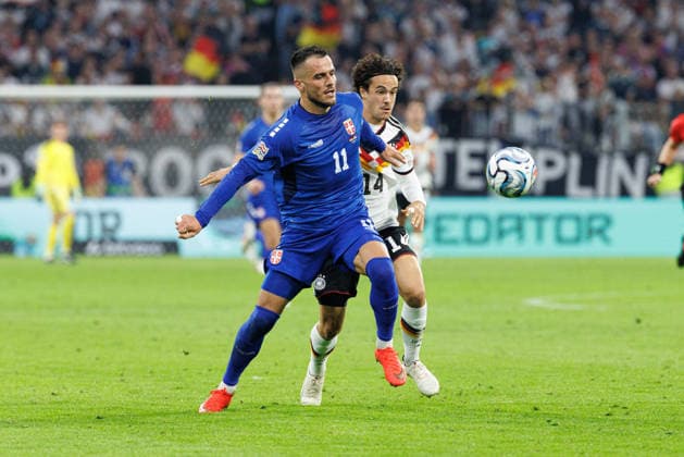 Filip Kostic (11), Serbia, and Mika Baur (14), Germany, during the match between Germany and Serbia, men s soccer, UEFA Nations League, 2026–2027, Matchday 3 on October 1, 2026, in Munich, Allianz Arena, Bavaria, Germany