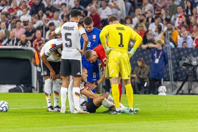 Soccer: UEFA Nations League 2026–2027, Matchday 3: Germany vs. Serbia at Allianz Arena, Munich. Waldemar Anton (Germany), No. 3, injured on the ground; Aleksandar Pavlovic (Germany), No. 5; Jonas Urig (Germany), No. 1 Copyright: xMichellexLukax