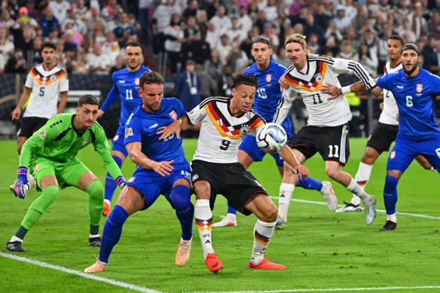 Derry SCHERHANT (GER) in action, tackling Strahinja ERAKOVIC (Serbia) Li; goalkeeper Djordje PETROVIC (Serbia) hi re; Nick WOLTEMADE (GER), Nemanja GUDELJ (Serbia) in the penalty area; soccer Nations League group stage, Group B, Matchday 3, Germany (GER) vs. Serbia (SRB) 2–0 on October 1, 2026, Allianz Arena