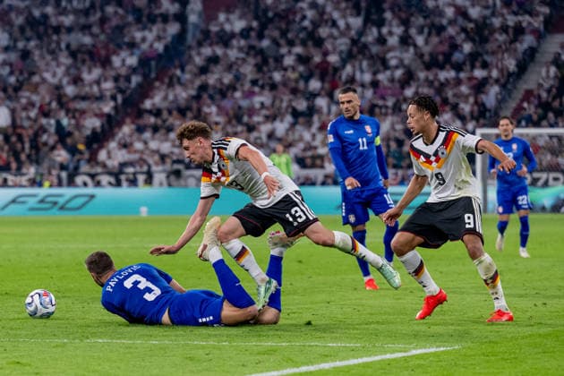 Philipp Treu (Germany, 13) takes down Strahinja Pavlovic (Serbia, 03), with Derry Scherhant (Germany, 09) behind them; Germany vs. Serbia, soccer, UEFA Nations League, League A group stage, Matchday 3, 2026–2027 season, October 1, 2026. DFL and DFB regulations prohibit any use of photographs as image sequences and or quasi-video. Photo: HMB Media, Heike Feiner Copyright: HMBxMedia HeikexFeiner