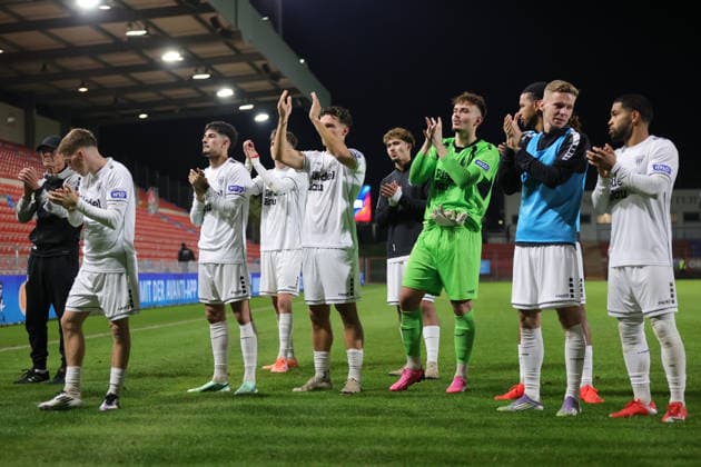 October 2, 2026, Soccer, Men s, Bavarian Regional League, 2026–2027 Season, Matchday 12: SpVgg Unterhaching vs. FC Schweinfurt 05. The Schweinfurt team poses for a photo with their traveling fans after the final whistle at Unterhaching Uhlsport Park, Unterhaching, Bavaria, Germany