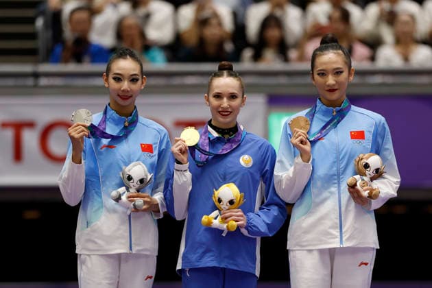 (261003) -- NAGOYA, Oct. 3, 2026 -- Gold medalist Takhmina Ikromova (C) of Uzbekistan, silver medalist Wang Qi (L) and bronze medalist Wang Zilu of China pose for photos during the awarding ceremony for the Individual All-Around of Rhythmic gymnastics, Rhythmische Sportgymnastik, RSG at 20th Asian Games Aichi-Nagoya 2026 in Nagoya, Japan, Oct. 3, 2026. ) (SP)JAPAN-NAGOYA-ASIAN GAMES-RHYTHMIC GYMNASTICS-INDIVIDUAL ALL-AROUND-FINAL WuxZhizun