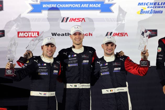 Robin Frjins (NED), Sheldon van der Linde (RSA), Dries Vanthoor (BEL) in the BMW M Hybrid V8 24, finishing second with trophies on the podium; awards ceremony; IMSA racing series; 29th Motul Petit Le Mans race; Road Atlanta, Georgia, USA; October 3, 2026, 10-hour race