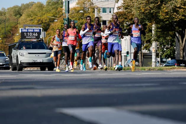 The leading group of men, led by the eventual winner, Kenyan Bernard Kiprop Koech (in the red jersey), third from the left at the 28th Generali Cologne Marathon in 2026, runs through downtown Cologne. Numerous spectators cheer on the runners with homemade signs. Thematic image, symbolic image. Cologne, October 4, 2026. North Rhine-Westphalia, Germany Copyright: xChristophxHardtx