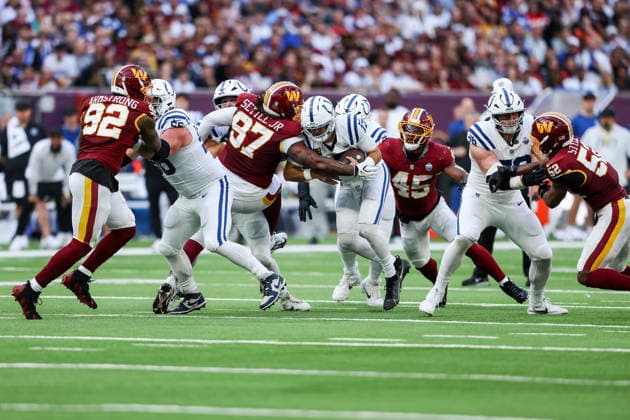 4th October 2026; Tottenham Hotspur Stadium, London, England; NFL, American Football Herren, USA International Series American football, Washington Commanders versus Indianapolis Colts; Indianapolis Colts quarterback Daniel Jones feels pressure from Washington Commanders defensive tackle Tim Settle HenningxVonxJagow