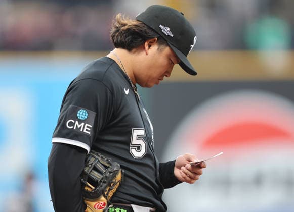Chicago White Sox first baseman Munetaka Murakami (5) reads a slip of paper during the fourth inning against the Cleveland Guardians in an MLB, Baseball Herren, USA American League Division Series playoff game at Progressive Field in Cleveland, Ohio, on Monday, October 5, 2026. CLE20261005716 AARONxJOSEFCZYK