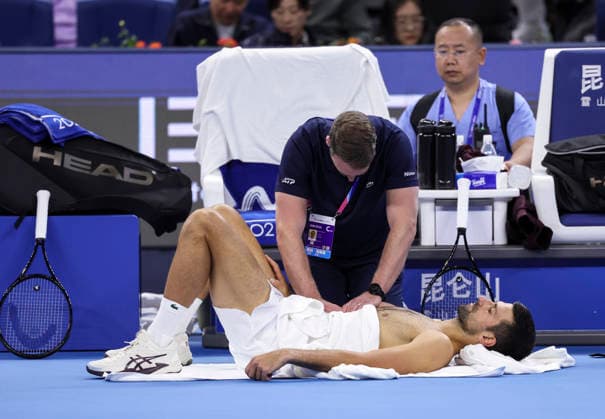 (261006) -- BEIJING, Oct. 6, 2026 -- Novak Djokovic (bottom) of Serbia receives medical treatment during the men s singles final match against Alex de Minaur of Australia at 2026 China Open tennis tournament in Beijing, China, Oct. 6, 2026. ) (SP)CHINA-BEIJING-TENNIS-CHINA OPEN-MEN S SINGLES-FINAL(CN) BaixXuefei 