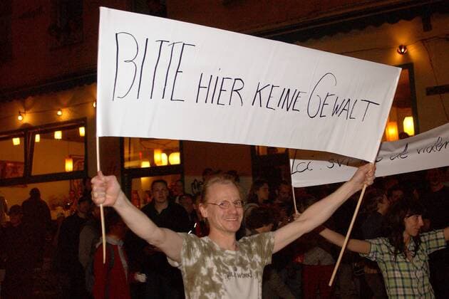 Demonstrant mit dem Transparent -Bitte hier keine Gewalt- - 1. Mai in Berlin-Kreuzberg