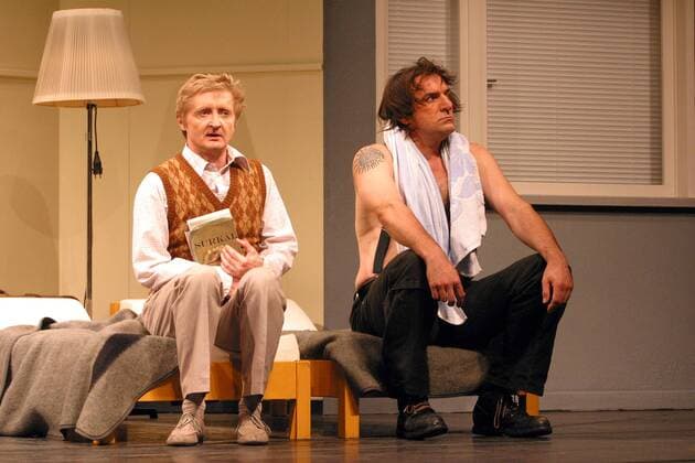 Schauspieler Michael Schreiner (li., GER Elling) und Andreas Hoppe (GER Kjell Bjarne) sitzen gemeinsam auf dem Bett während der Fotoprobe zur norwegischen Komödie ELLING im Berliner Theater am Kurfürstendamm